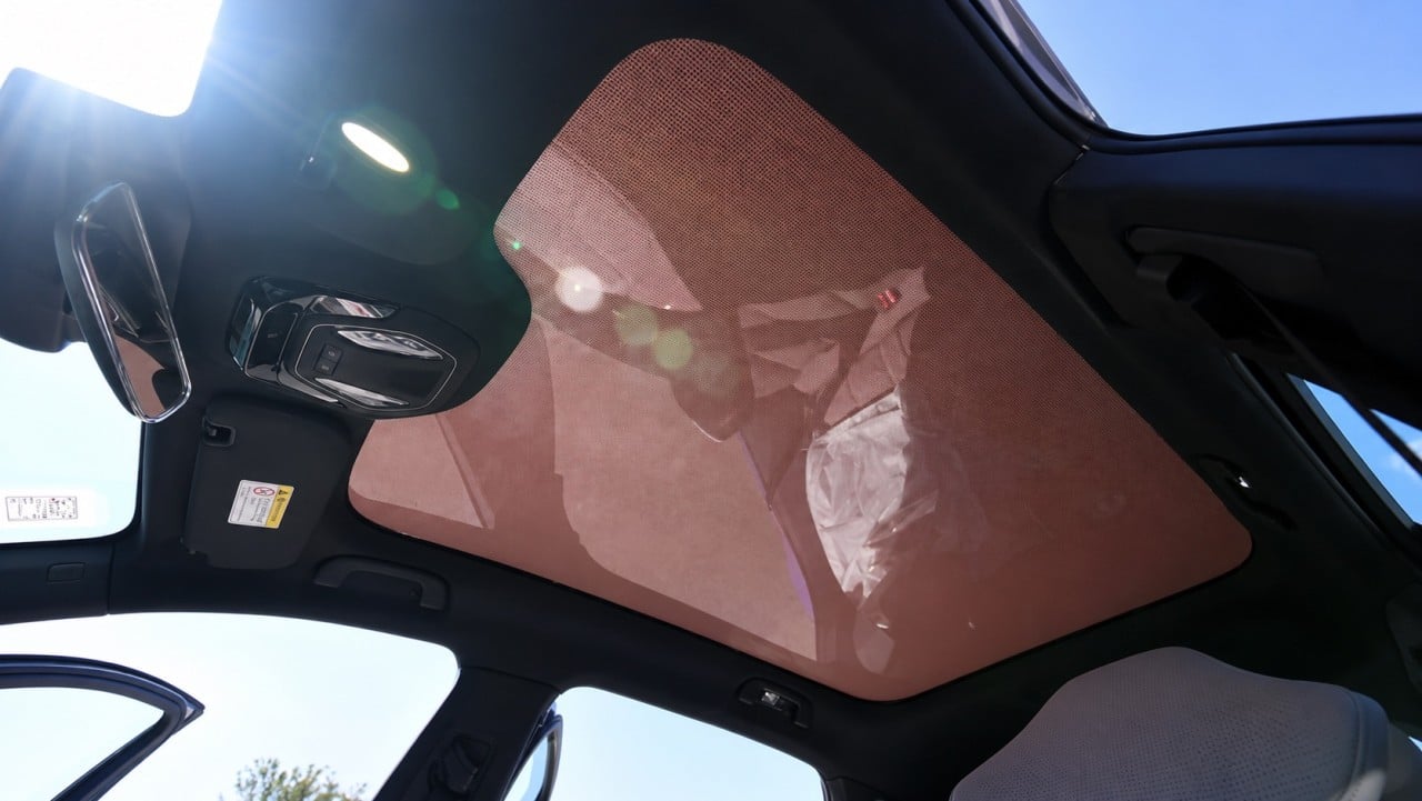 Un veicolo elettrico con un tetto trasformato in pannello solare, in un parcheggio, con luce del sole