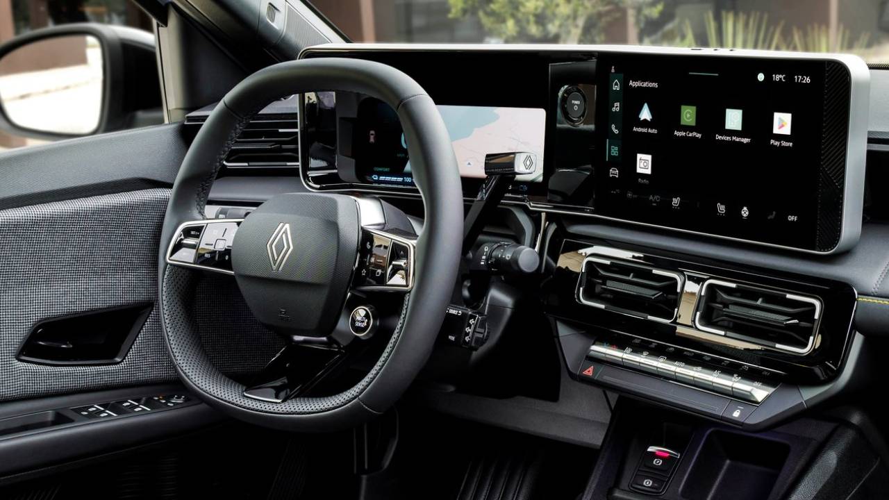 Un automobilista si avvicina a un veicolo elettrico, con un pulsante inutilizzato sul cruscotto, mentre si prepara a guidare