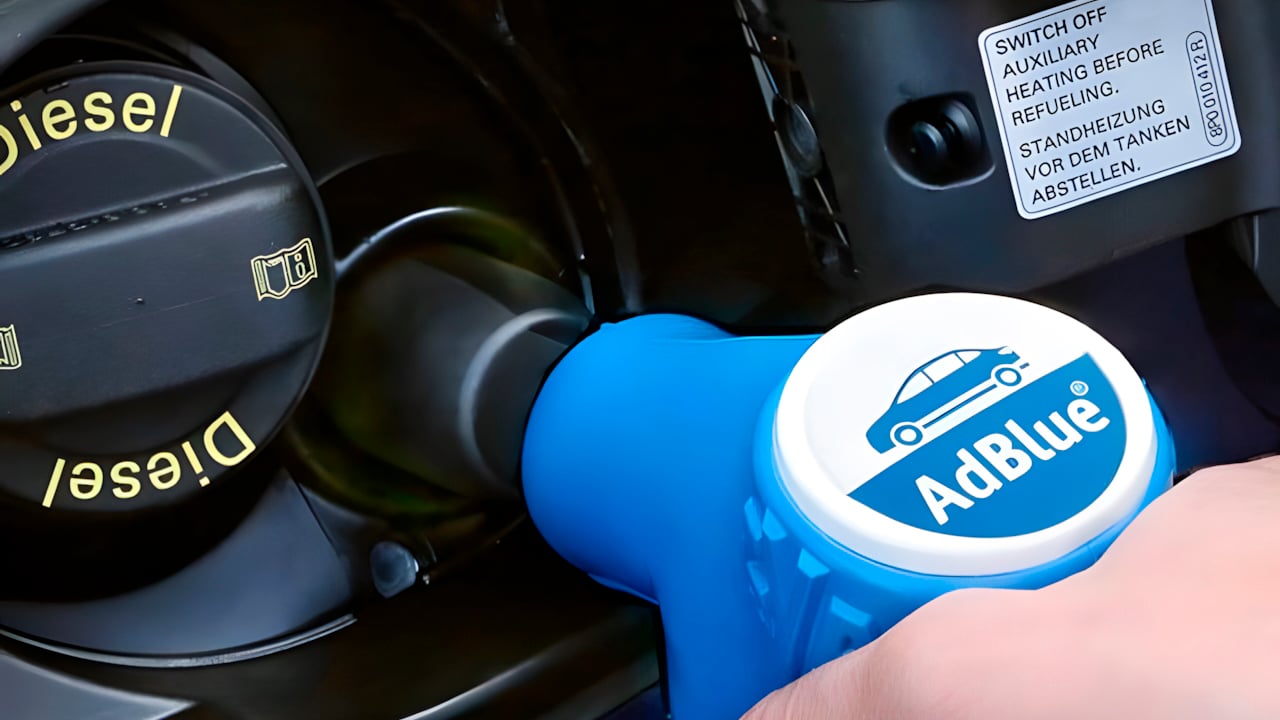 Un'auto ibrida con serbatoio di diesel e AdBlue, con un'etichetta di emissioni, in un'area di parcheggio