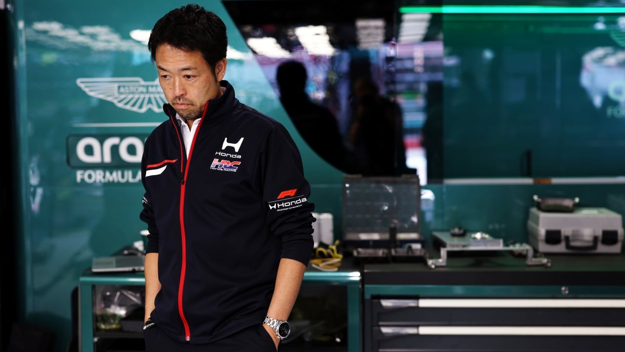 Ingegneri Honda lavorano su un motore per Aston Martin in un laboratorio tecnico, con strumenti e schemi tecnici