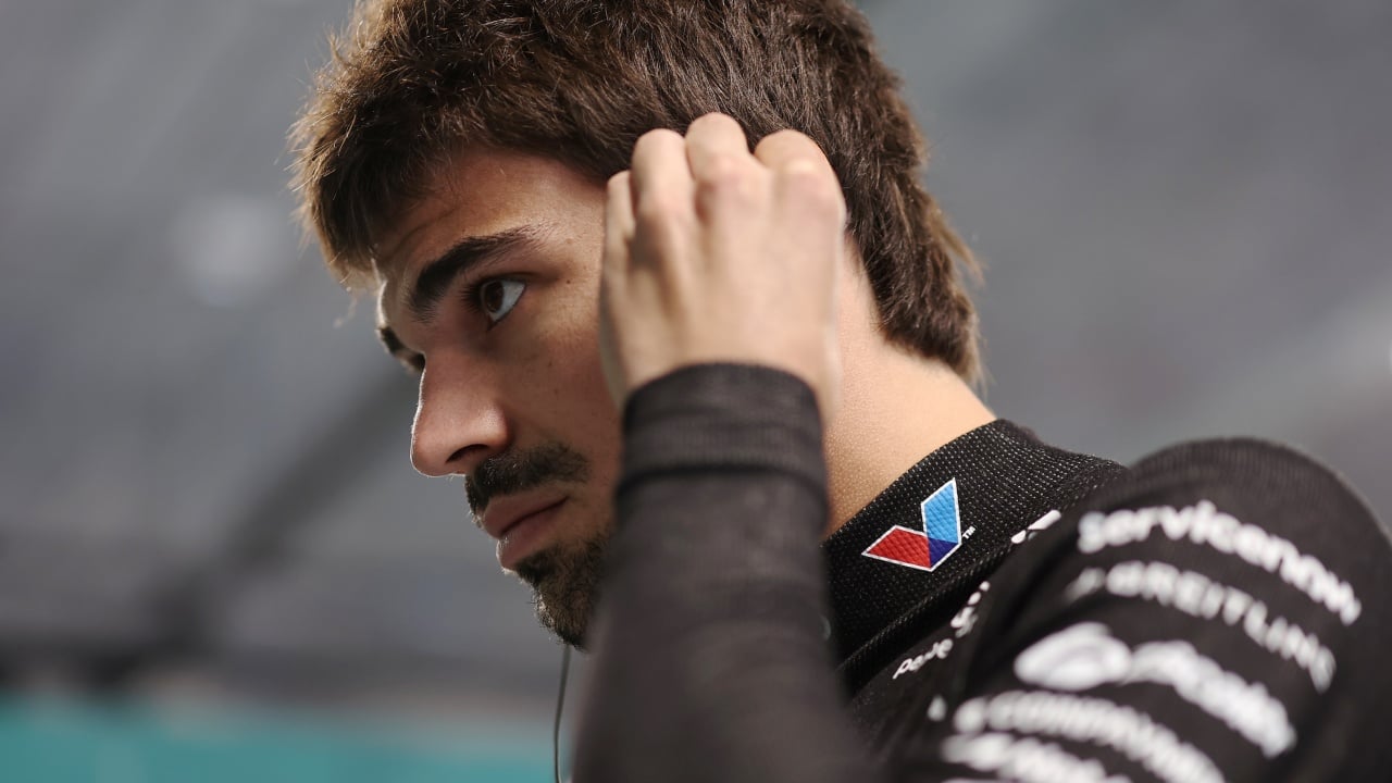 Lance Stroll in pista durante una gara di Formula 1, con il casco e la tuta, in un tratto di curva