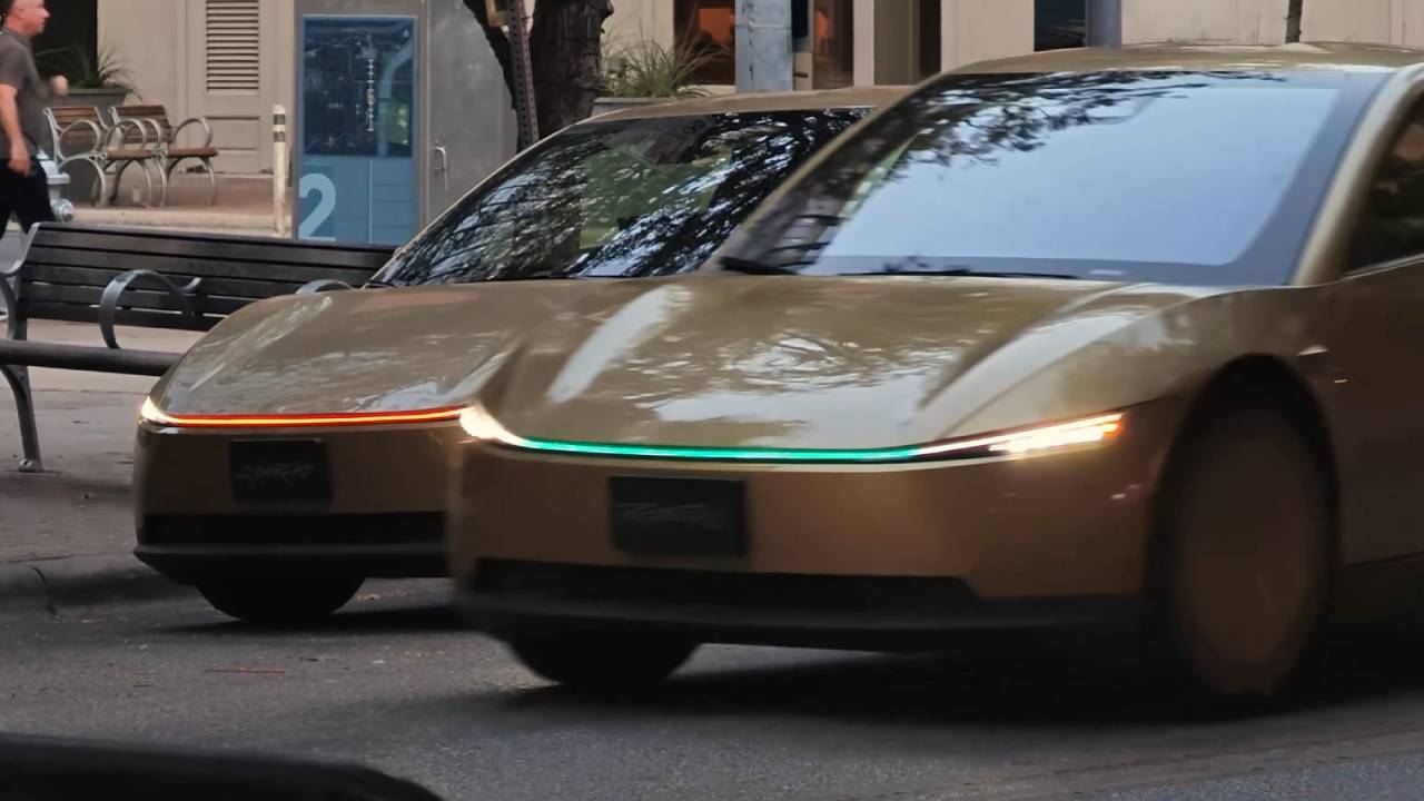 Un Tesla Cybercab mostra una luce verde nei fari per identificare il veicolo, in un futuro con robotaxi